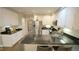 Modern kitchen featuring white cabinets, stainless steel appliances, and a black granite countertop island at 1505 Sharnbrook Ct, Raleigh, NC 27614