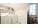Bright laundry room featuring modern washer and dryer units, complete with practical overhead shelving at 1505 Sharnbrook Ct, Raleigh, NC 27614
