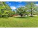 Spacious backyard with a well-manicured lawn and mature trees, providing a serene and private outdoor retreat at 154 Luther Rd, Raleigh, NC 27610