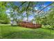 Green backyard with mature trees and a large deck at 154 Luther Rd, Raleigh, NC 27610