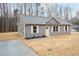 Charming gray home with a gray roof, white trim and yellow door, with a concrete driveway at 156 Southern Middle School Rd, Roxboro, NC 27573