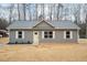 Charming gray home with a gray roof, white trim and yellow door, set in a wooded location at 156 Southern Middle School Rd, Roxboro, NC 27573