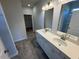 Bright bathroom featuring double sinks, granite countertop, large mirror and gray tile floor at 182 E Victory View Ter, Smithfield, NC 27577
