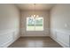 Elegant dining room with wainscoting, modern chandelier, and a large window at 182 E Victory View Ter, Smithfield, NC 27577