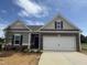 Charming single-story home featuring stone accents, a two-car garage, and manicured landscaping at 182 E Victory View Ter, Smithfield, NC 27577