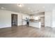 Open concept kitchen featuring white cabinets, a center island, hardwood floors and modern stainless appliances at 182 E Victory View Ter, Smithfield, NC 27577