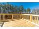 Spacious wooden deck with wood railings overlooks a beautiful lush green and wooded area at 213 Delma Grimes Rd, Coats, NC 27521