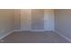 A carpeted bedroom with neutral colored walls and two white doors, offering quiet at 213 Delma Grimes Rd, Coats, NC 27521