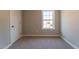 Carpeted bedroom with a large window allowing ample natural light and a closet at 213 Delma Grimes Rd, Coats, NC 27521