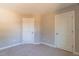 Carpeted bedroom with two doors, baseboard trim and natural lighting at 213 Delma Grimes Rd, Coats, NC 27521