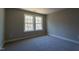 A carpeted bedroom with natural light has neutral-colored walls and double windows at 213 Delma Grimes Rd, Coats, NC 27521