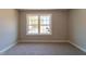 An airy carpeted bedroom with natural light features double windows and neutral walls at 213 Delma Grimes Rd, Coats, NC 27521
