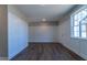 Well-lit living room with hardwood floors, wainscoting wall trim, and a view leading to other areas of the house at 213 Delma Grimes Rd, Coats, NC 27521