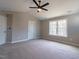 Primary bedroom featuring neutral paint, carpet, and large picture window overlooking a wooded area at 213 Delma Grimes Rd, Coats, NC 27521