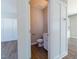 Downstairs powder room featuring wood floors, a white vanity, and modern fixtures at 213 Delma Grimes Rd, Coats, NC 27521