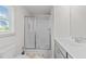 This bathroom has a vanity with a sink, a glass enclosed shower and a window at 220 Brisbane Dr, Zebulon, NC 27597
