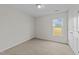 An empty room with a door, a window, neutral walls and carpeting at 220 Brisbane Dr, Zebulon, NC 27597