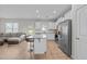 Open-concept kitchen and living room with white cabinets, stainless appliances, and a comfortable sofa at 220 Brisbane Dr, Zebulon, NC 27597