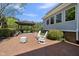 The home's back patio features brick pavers, white chairs, a fire pit, and an outdoor kitchen area at 220 Jordan Narron Rd, Selma, NC 27576