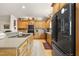 Modern kitchen features wood cabinets, an island, and a black refrigerator for a sleek and functional cooking space at 220 Jordan Narron Rd, Selma, NC 27576