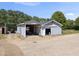 Exterior view of a versatile outbuilding with a covered parking area and roll-up door, ideal for storage at 220 Jordan Narron Rd, Selma, NC 27576