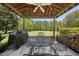 Enjoy cooking outside under this covered outdoor kitchen with a grill and a table with chairs at 220 Jordan Narron Rd, Selma, NC 27576