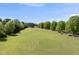 Expansive pasture with green grass surrounded by trees and wooden fences on a sunny day at 220 Jordan Narron Rd, Selma, NC 27576