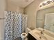 Well-lit bathroom with vanity, mirror, and shower with patterned curtain at 226 Kandypoo Dr, Four Oaks, NC 27524