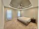 Relaxing main bedroom featuring neutral carpet, a ceiling fan, tray ceiling, and great natural light at 226 Kandypoo Dr, Four Oaks, NC 27524