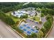 Aerial view showcases community amenities: pool, tennis courts, and clubhouse surrounded by lush greenery at 2307 Carriage Oaks Dr, Raleigh, NC 27614