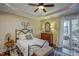 This bedroom features a tray ceiling, wood floors, natural light, and a balcony at 2307 Carriage Oaks Dr, Raleigh, NC 27614