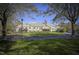 Stately yellow home with a well-manicured lawn and mature trees creating a picturesque setting at 2307 Carriage Oaks Dr, Raleigh, NC 27614