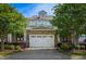 Charming townhome featuring a two-car garage, stone accents, and landscaped front yard for added curb appeal at 2307 Carriage Oaks Dr, Raleigh, NC 27614