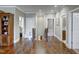 Hallway with hardwood floors, white trim, and multiple doorways leading to various rooms at 2307 Carriage Oaks Dr, Raleigh, NC 27614
