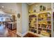 Hallway with hardwood flooring leading to the kitchen and living areas, with a view of a bookshelf at 2307 Carriage Oaks Dr, Raleigh, NC 27614