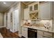 Kitchen bar area with granite counters, backsplash, wine rack, wine glass rack, and wine fridge at 2307 Carriage Oaks Dr, Raleigh, NC 27614