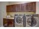 Bright laundry room with upper cabinets, counter space and stainless steel washer and dryer at 2307 Carriage Oaks Dr, Raleigh, NC 27614