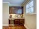 An elegant wet bar features dark wood cabinets, granite countertops, and a wine cooler at 2307 Carriage Oaks Dr, Raleigh, NC 27614