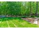 Expansive backyard features manicured lawn and mature landscaping, with privacy fence at 2412 Castleburg Dr, Apex, NC 27523