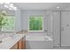 Bathroom with dual sinks, soaking tub, and glass shower at 2412 Castleburg Dr, Apex, NC 27523
