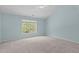 This bedroom features carpet, a ceiling fan, and a large window at 2412 Castleburg Dr, Apex, NC 27523