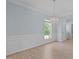 Elegant dining room with hardwood floors, wainscoting, a crystal chandelier, and ample natural light at 2412 Castleburg Dr, Apex, NC 27523