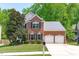 Traditional brick home with a well-kept lawn, mature tree, two-car garage, and a mailbox at 2412 Castleburg Dr, Apex, NC 27523