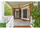 Inviting covered front porch with brick accents, a hanging light fixture, and a decorative welcome mat at 2412 Castleburg Dr, Apex, NC 27523