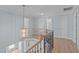 Upstairs hallway featuring wood floors, decorative railing, and chandelier at 2412 Castleburg Dr, Apex, NC 27523