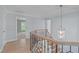 Upstairs hallway featuring wood floors, decorative railing, and chandelier at 2412 Castleburg Dr, Apex, NC 27523