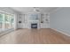 Bright living room featuring hardwood floors, a fireplace with built-in cabinets, and large windows at 2412 Castleburg Dr, Apex, NC 27523