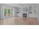 Cozy living room with a fireplace, built-in shelving, hardwood floors, and large windows at 2412 Castleburg Dr, Apex, NC 27523