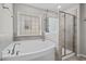 This primary bathroom has a soaking tub, a glass enclosed shower, and gray tile at 2912 Historic Cir, Morrisville, NC 27560