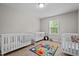 Bright bedroom featuring three cribs, a window, and colorful alphabet rug at 2912 Historic Cir, Morrisville, NC 27560